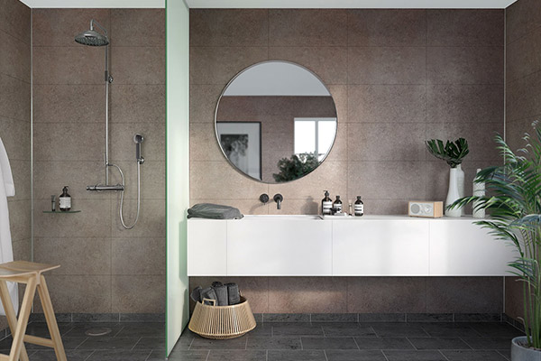 Wet room bathroom in a neutral colour scheme with a round mirror as a focus point