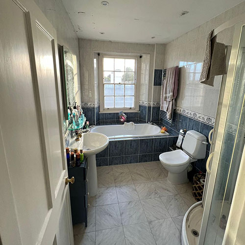 A before picture of a customer bathroom with Blue and white tiles