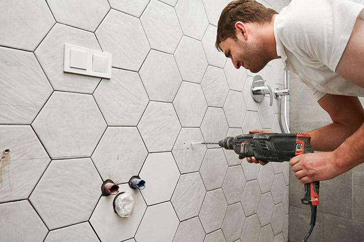 Bathroom fitter installing shower fixtures in new bathroom